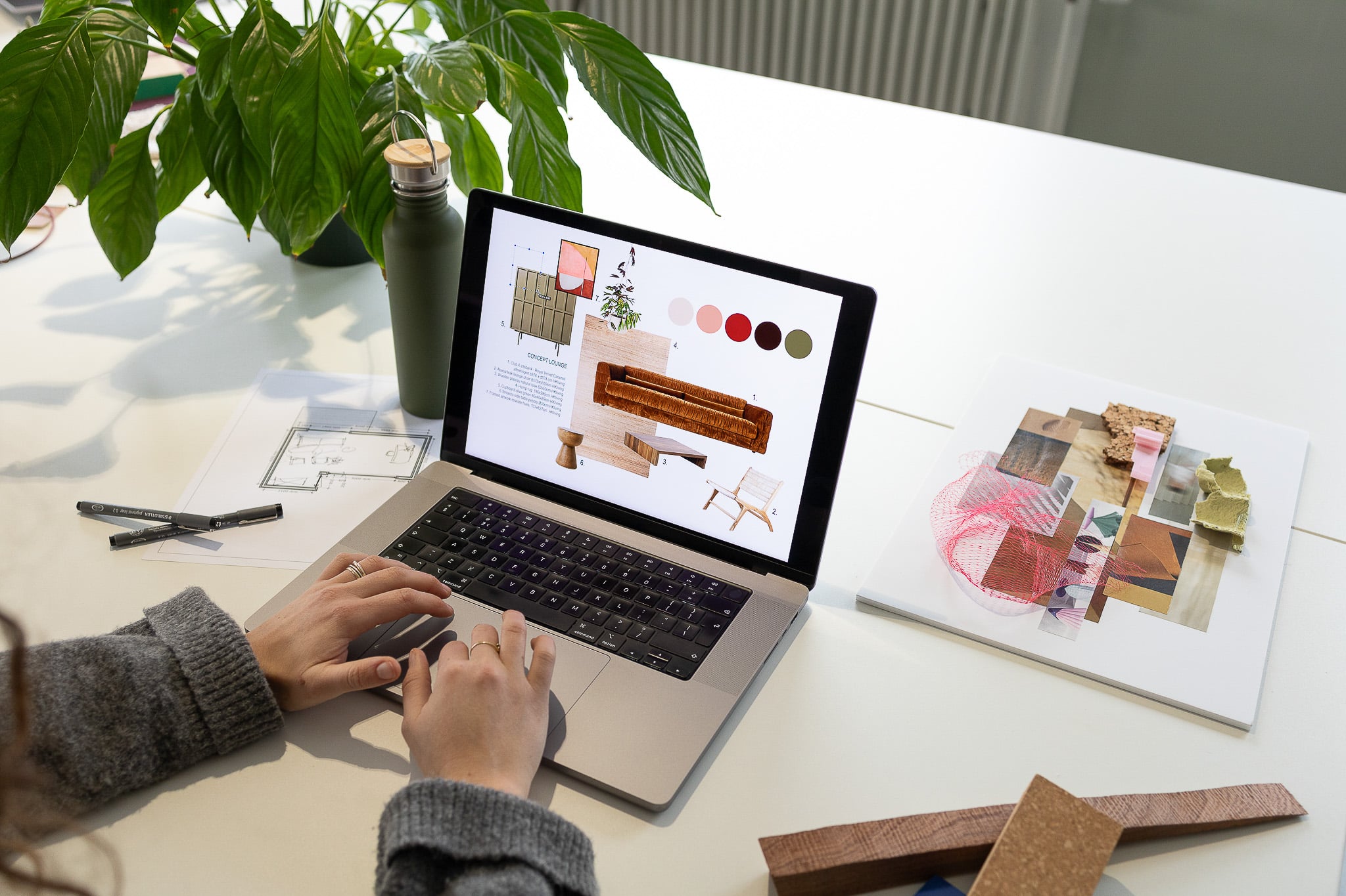 Vrouw werkt aan een interieur moodboard achter een computer